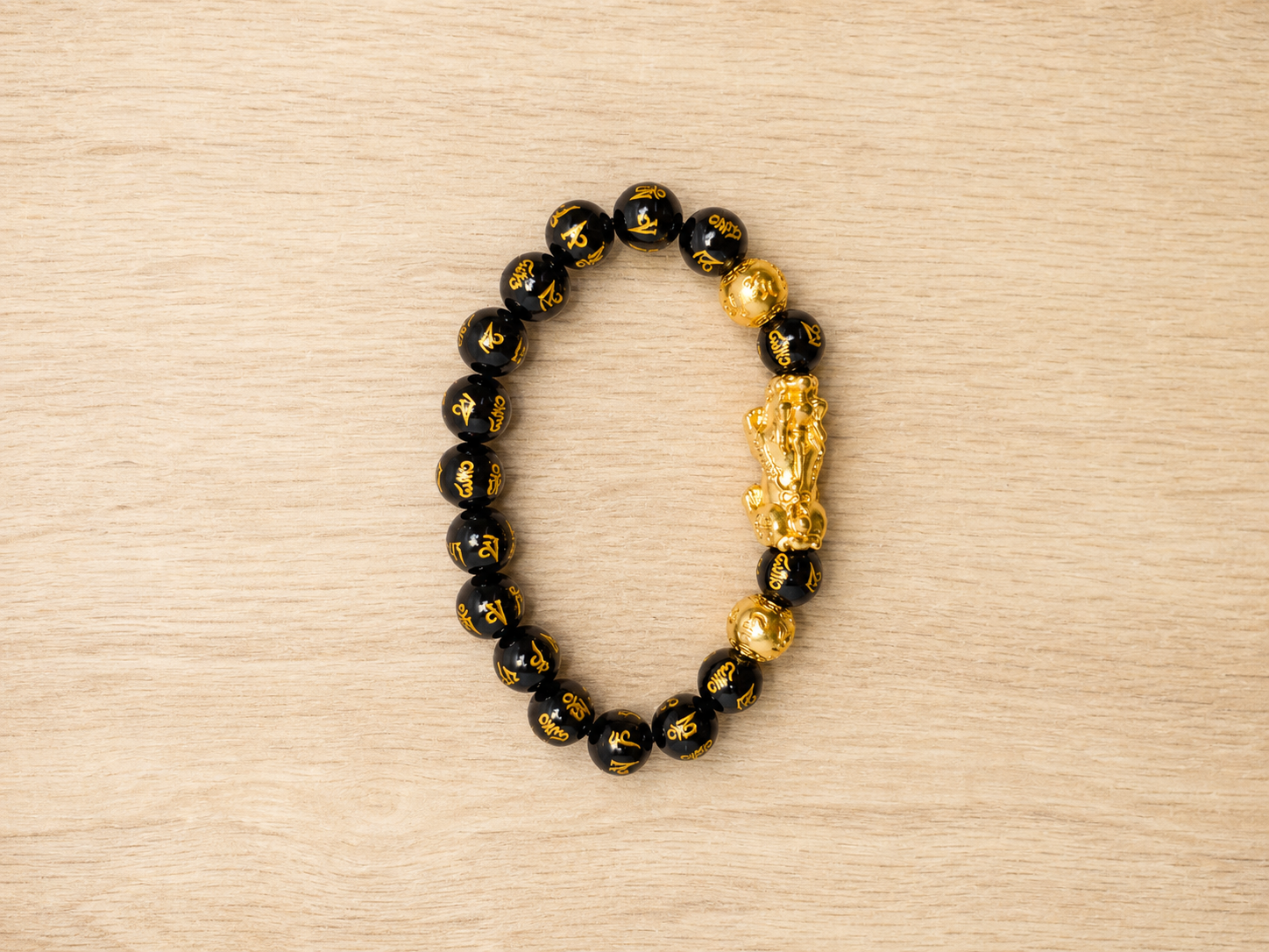 Pixiu black obsidian bracelet shown from above for bead and centerpiece inspection.