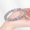 Gray moonstone bead bracelet held in hand under bright light