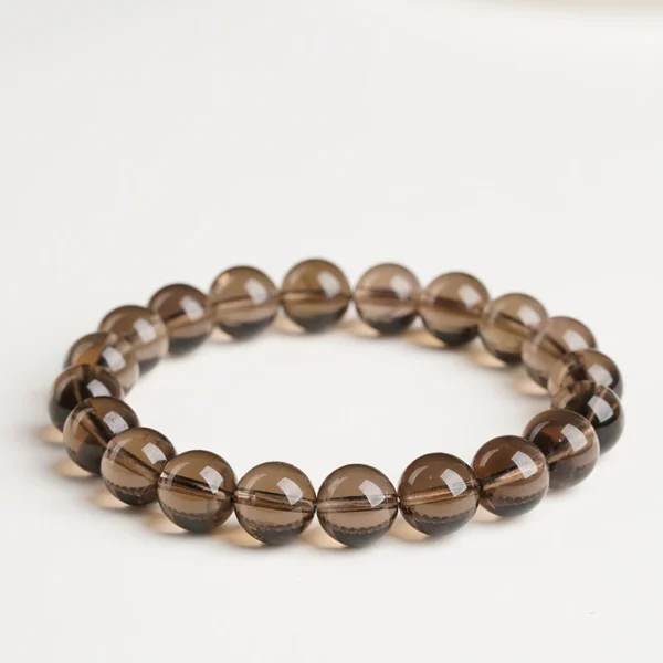 Single-strand smoky quartz bead bracelet on a light surface