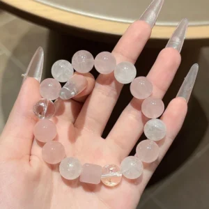 Pale pink and clear-white mixed quartz bracelet shown across the palm