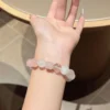 Rose quartz and white phantom quartz bracelet worn on the wrist
