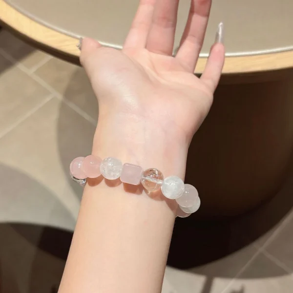 Rose quartz and white phantom quartz bracelet worn on the wrist