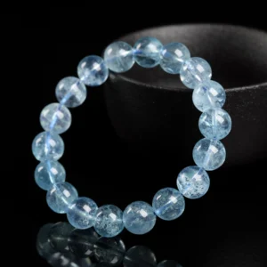 Aquamarine bracelet with ice-blue 8mm round beads on a dark display