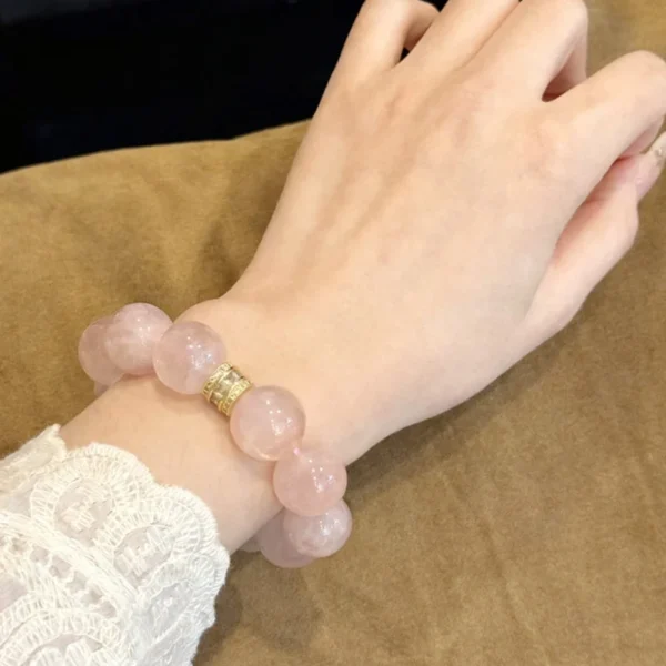 Rose quartz bracelet with 14mm round beads worn on the wrist
