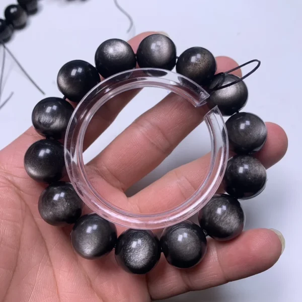 Silver Sheen Black Obsidian Bracelet Handheld Silver sheen and black obsidian bracelet hand-held view